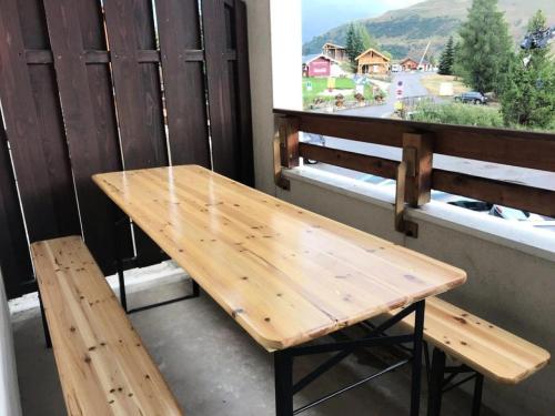 d'une table et d'un banc en bois sur un balcon avec vue. dans l'établissement Résidence Christiania - APPARTEMENT ALPE D'HUEZ QUARTIER BERGERS MAE-3181, à Huez