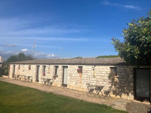 a brick building with benches in front of it at Nacalino Agriturismo in Modica