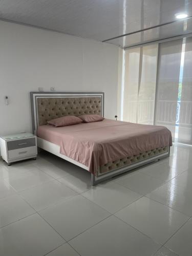 a bed in a white room with a large bed sidx sidx sidx at Finca Hotel Villa el Ocaso Huila in Rivera
