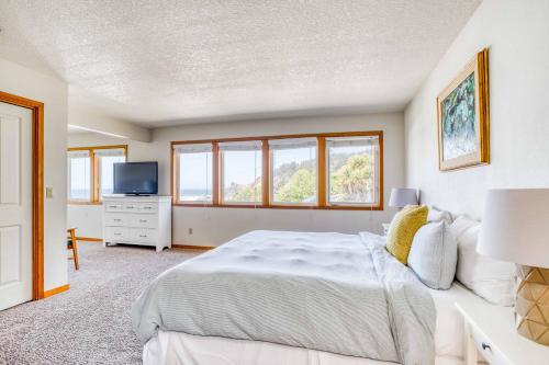 a bedroom with a bed and a tv and windows at Sands of Time in Lincoln City