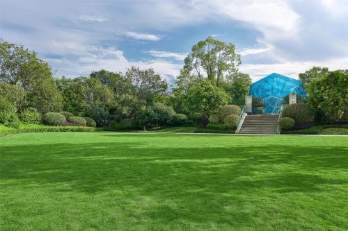 a green yard with a blue building in the background at Kempinski Hotel Fuzhou in Fuzhou