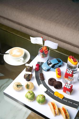 a table topped with different types of donuts and a cup of coffee at Kempinski Hotel Fuzhou in Fuzhou