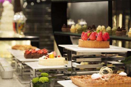 a buffet line of cakes with strawberries on them at Kempinski Hotel Fuzhou in Fuzhou