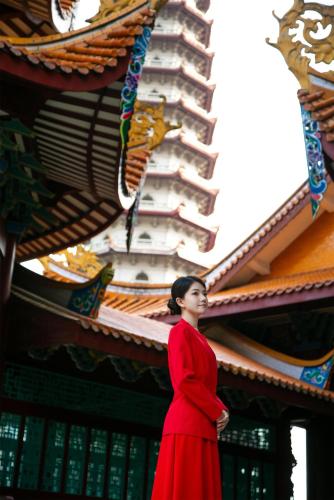 a woman in a red dress standing in front of a building at Kempinski Hotel Fuzhou in Fuzhou