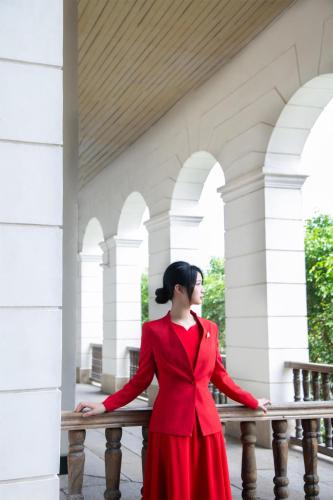 a woman in a red dress standing next to a railing at Kempinski Hotel Fuzhou in Fuzhou