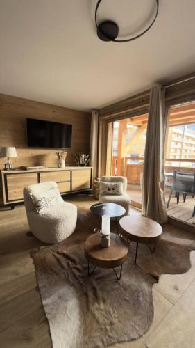 - un salon avec deux chaises et deux tables dans l'établissement Résidence Christina - Appartement 4 PIECES + GARAGE/SKIS AUX PIEDS/WIFI MAE-3551, à Huez