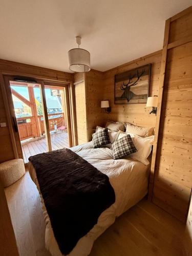 une chambre avec un grand lit avec un mur en bois dans l'établissement Résidence Christina - Appartement 4 PIECES + GARAGE/SKIS AUX PIEDS/WIFI MAE-3551, à Huez