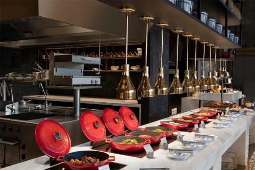 a buffet line with red plates and bowls of food at Kempinski Hotel Hangzhou in Hangzhou