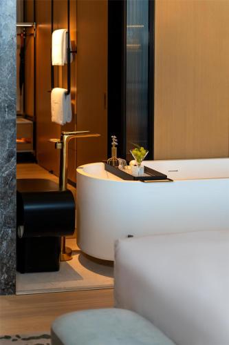 a bathroom with a bath tub and a sink at Kempinski Hotel Hangzhou in Hangzhou