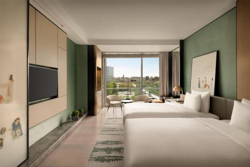 a hotel room with four beds and a tv at Kempinski Hotel Hangzhou in Hangzhou