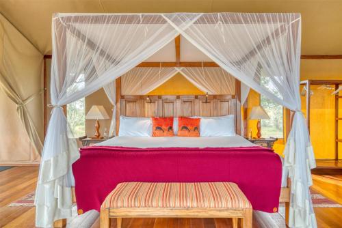 a bedroom with a bed with a canopy at Olare Mara Kempinski in Talek