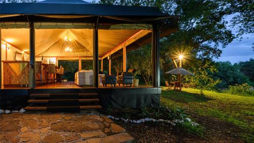 a tent with a table and chairs in a field at Olare Mara Kempinski in Talek