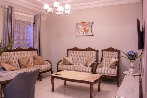 a living room with two couches and a table at Rovie Estates in Buea