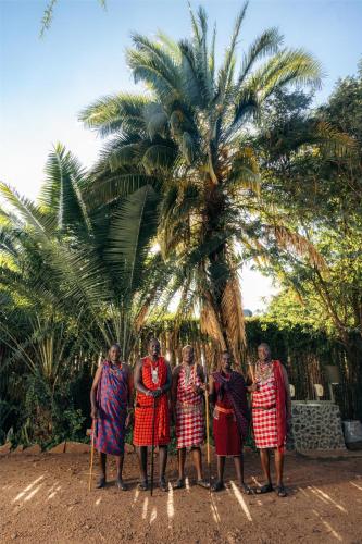 a group of men standing in front of a palm tree at Olare Mara Kempinski in Talek