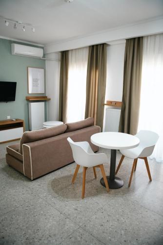 a living room with a couch and a table and chairs at Alexandros in Giannitsa