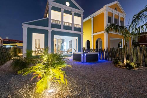 a yellow and blue house with palm trees in front of it at Vacation Home Bonaire in Kralendijk