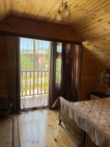 a bedroom with a bed and a large window at Green Field Cottage,Chakvi in Batumi