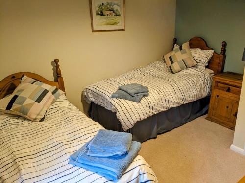 a bedroom with two beds with towels on them at The Byre in Yeaton