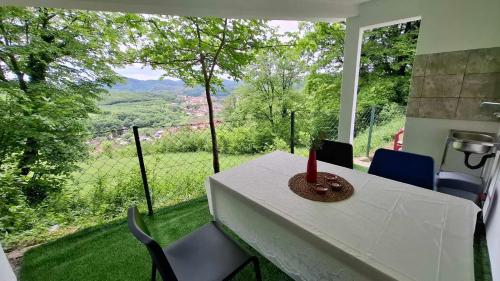 a table and chairs in a room with a view at Vikendica Weekend story Tuzla in Gornja Tuzla