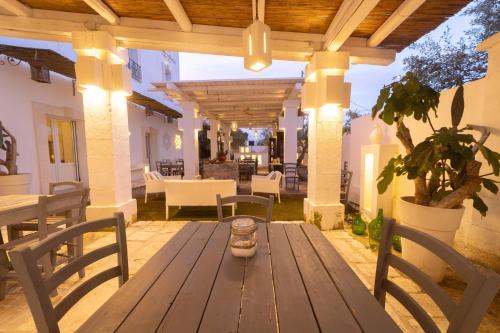 a wooden table and chairs on a patio at Masseria Messapia Wine Resort & Spa Salento in Mesagne