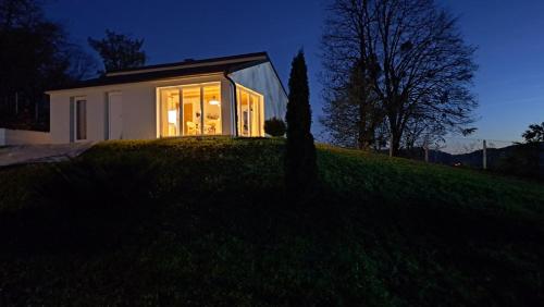 a small house on top of a hill at night at Vikendica Weekend story Tuzla in Gornja Tuzla