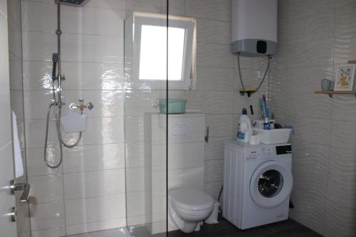 La salle de bains est pourvue de toilettes et d'un lave-linge. dans l'établissement Apartman Lavanda, à Šibenik