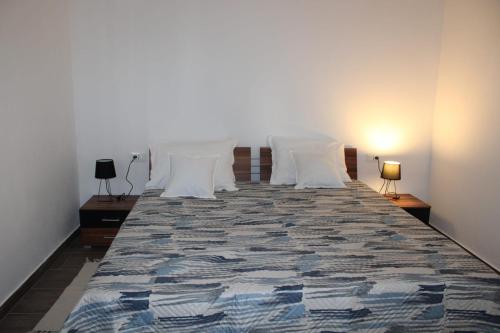 une chambre avec un grand lit avec des oreillers blancs dans l'établissement Apartman Lavanda, à Šibenik