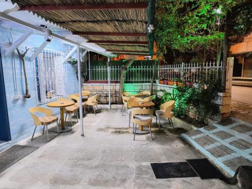 a group of tables and chairs in a restaurant at War Bunker Hostel in Sarandë