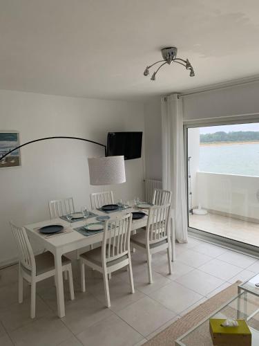 une salle à manger avec une table et des chaises et une fenêtre dans l'établissement Carnac appartement cosy avec vue mer, à Carnac