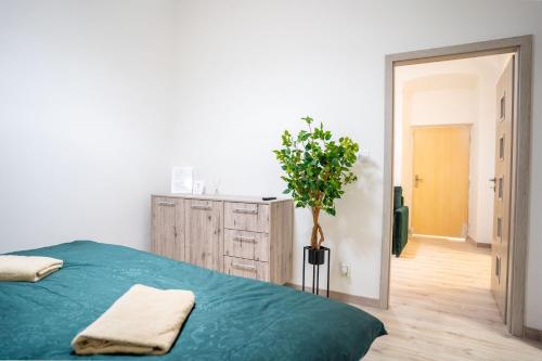 a bedroom with a green bed and a potted plant at Cozy Main Square Apartment II with Breakfast in Košice