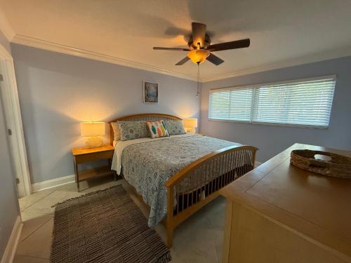 a bedroom with a bed and a ceiling fan at Treasure Island Beach, FL Waterfront Condo Located Steps away from the Intracoastal Waterway in St Pete Beach