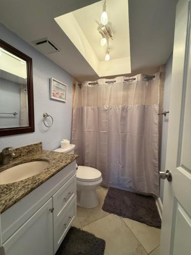 a bathroom with a sink and a toilet and a shower at Treasure Island Beach, FL Waterfront Condo Located Steps away from the Intracoastal Waterway in St Pete Beach
