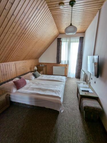 a bedroom with a large bed with a wooden ceiling at Gründner Vendégház in Siófok
