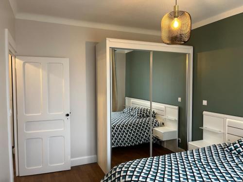 a bedroom with two beds and a mirror at Appartement Quartier Jardin Public in Parthenay