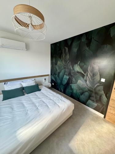 une chambre avec un grand lit avec un tableau au mur dans l'établissement Maison Moderne piscine chauffée, à Saint-Hilaire-de-Brethmas