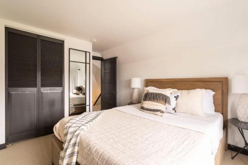 ポートランドにあるStay Portland - Scandinavian Loft - Local Espresso & Boutiquesの白いシーツと枕が付いた大きなベッドのある寝室