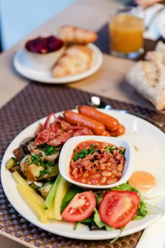 a plate of food with vegetables and beans on a table at Hotel Moments Budapest by Continental Group in Budapest