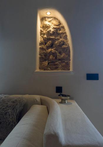 a room with a couch and a stone wall at La Boheme in Níjar
