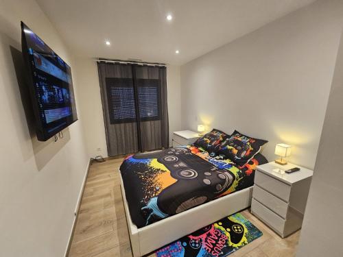a bedroom with a bed and a flat screen tv at Maison de vacances familiale avec piscine in Thuir