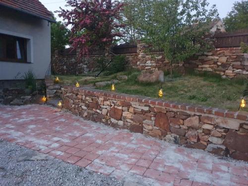 a stone retaining wall with lights in a yard at Statek U Šimla in Lážovice
