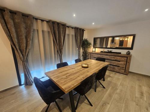 une salle à manger avec une table et des chaises en bois dans l'établissement Maison de vacances familiale avec piscine, à Thuir