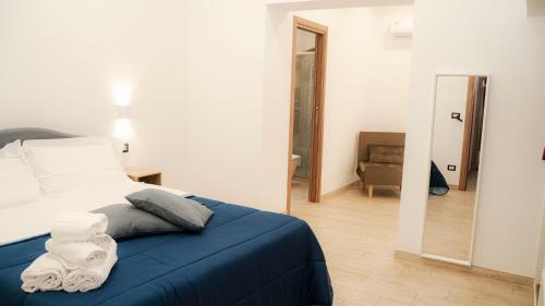 a bedroom with a bed with a blue blanket at Gira, vota e furria in Giardini Naxos
