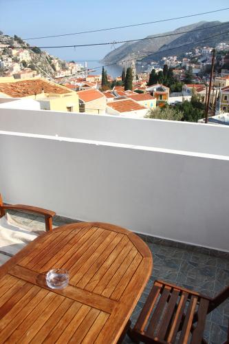 a wooden table on a balcony with a view of a city at Eos Studios in Symi