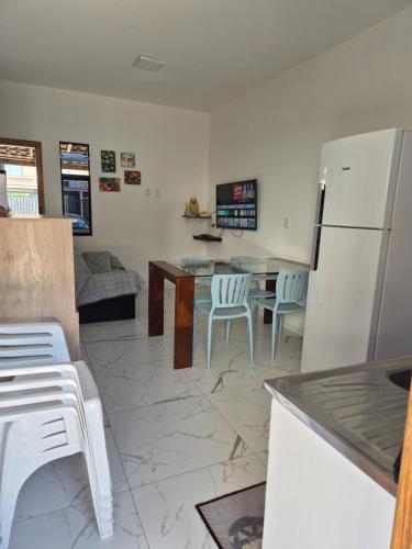 a kitchen with a refrigerator and a table and chairs at Casa praia in Itajubá