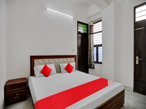 a bedroom with a large bed with red pillows at Hotel O Hotel Valentine's in Rohtak