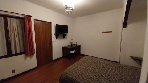 a bedroom with a bed and a television in it at Mansión de la Bolivia in La Paz