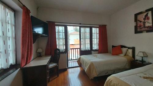 a hotel room with two beds and a window at Mansión de la Bolivia in La Paz