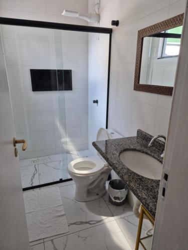 a bathroom with a toilet and a sink and a shower at Casa praia in Itajubá