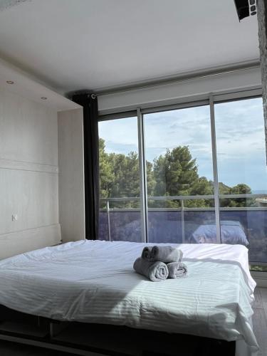 un lit dans une chambre avec une grande fenêtre dans l'établissement Clap de Soleil Studio Vue Mer, Clim, Fibre, Idéal 2 Pers, à La Ciotat