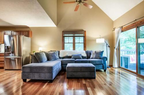 a living room with a blue couch and a refrigerator at Black Bear Lookout by Avada Properties in Townsend